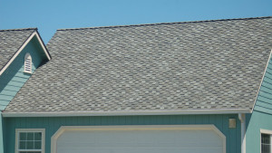 Green house with a full shot of the steep roof and asphalt shingles